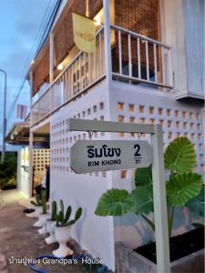 a street sign in front of a building at บ้านปู่ทอง Grandpa's House in Chiang Khan