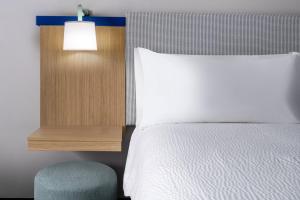a bedroom with a bed and a chair and a lamp at Garner Hotel Glen Burnie BWI Airport Area by IHG in Glen Burnie +14 photos