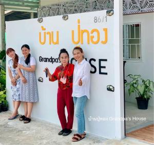 a group of women standing in front of a sign at บ้านปู่ทอง Grandpa's House in Chiang Khan