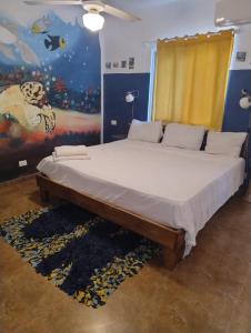a large bed in a room with a painting on the wall at Brisa de Alma Guesthouse in Bayahibe