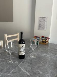 圣萨尔瓦多德朱Apartamentos La Posta的桌上放着一瓶葡萄酒，旁边还有两个酒杯