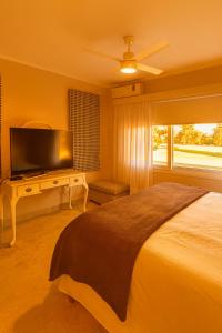 a bedroom with a bed and a flat screen tv at Gran casa Country Golf Club in Gualeguaychú