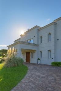 a large white house with a driveway at Gran casa Country Golf Club in Gualeguaychú