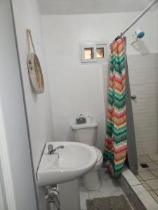 a white bathroom with a sink and a toilet at First Floor 2 Bed Apartment in La Ceiba