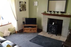 Μια τηλεόραση ή/και κέντρο ψυχαγωγίας στο 4 Bed Cottage Sleeps 6-Pet-Friendly-Private Garden