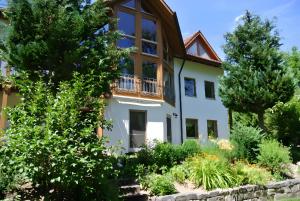 a large white house with a balcony at Naturferienwohnung Am Lautergarten in Indelhausen