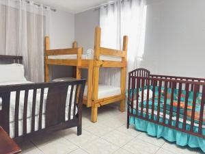 un dormitorio con dos literas y una cuna en Cabanas Playa Santa/ Apto. A/ Swimming Pool/ Pool Table/ WIFI/ 3 min Beaches, en Guánica 48 fotos más