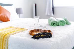 a bottle and two glasses on top of a bed at Short North - Convention - Private Parking - Pets - 2BR in Columbus