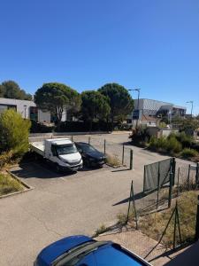 a parking lot with parked cars and a truck at Appartement face Aéroport Marseille in Vitrolles