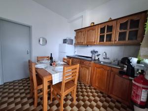 Una cocina con mesa y sillas y un refrigerador. en Varanda Encantada House, en Ponta do Sol