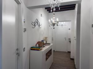 カスティリオーネ・ドルチャにあるFonte Alle Ninfe Bed and Breakfastの白い部屋(テーブル、シャンデリア付)