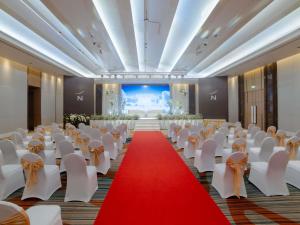 a banquet hall with white chairs and a red carpet at Novotel Phuket City Phokeethra in Phuket Town