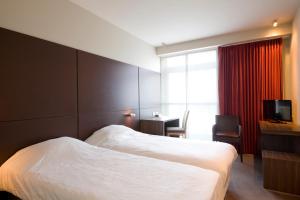 een hotelkamer met een bed en een televisie bij Parkhotel Izegem in Izegem