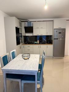 a kitchen with a table with chairs and a refrigerator at Apartament cu 2 camere in Rădăuţi