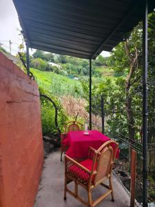 a table with a pink table cloth on a patio at Luci's House B in São Jorge