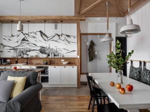 a kitchen and living room with a couch and a table at Tatry Top Apartamenty Granitica centrum in Zakopane