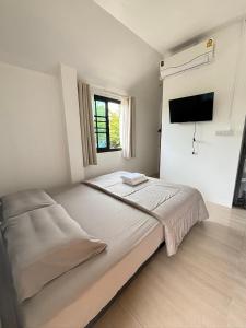 a bedroom with a bed and a tv on the wall at D sleep Home Chiangmai in Chiang Mai