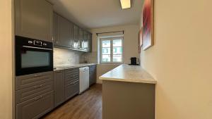a kitchen with stainless steel appliances and a large window at Casa Tantris zentral und modern mitten in Gmund in Gmund am Tegernsee