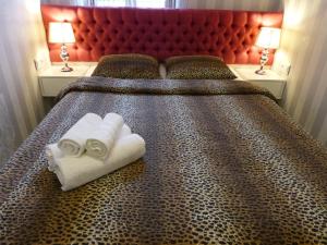 a bed with two towels on it with two lamps at Apartament 46m2 z tarasem i wanną Asenata Ustroń in Ustroń