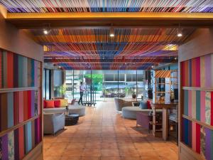 a lobby with couches and chairs and a colorful ceiling at Mercure Bangkok Sukhumvit 11 in Bangkok +93 photos