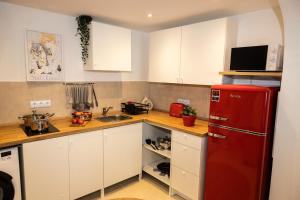 a kitchen with a red refrigerator and white cabinets at Motel Kalos in Haiger
