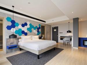 a bedroom with a large bed and a fireplace at ibis Styles Batam Nagoya in Nagoya