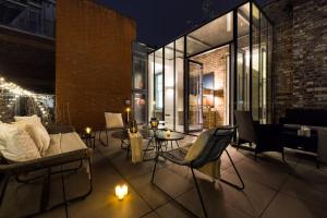 a patio with a couch and chairs and candles at Comfortable luxury apartments near the Center - London in Southport