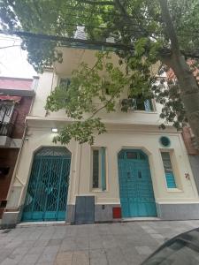 a house with blue doors on a street at Roosevelt in Buenos Aires +142 photos