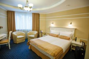 ヴォロネジにあるDegas Voronezh Centerのベッドとデスクが備わるホテルルームです。