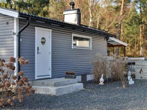 a gray house with a white door and a house at 4 person holiday home in LÖDDEKÖPINGE in Löddeköpinge