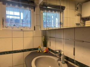a bathroom sink with two dolls sitting on it at Ferienhaus mit Kamin in Sternberg in Sternberg +27 photos