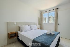 a bedroom with a large white bed with a window at Apartamentos a 220 m da Praia em Balneário Picarras - CSI in Piçarras +49 photos