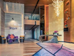 a lobby with a chair and a table in a building at Mercure Bangkok Makkasan in Bangkok