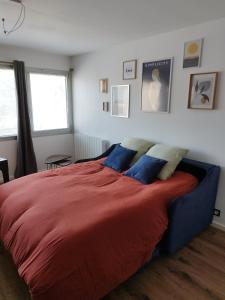 パンポルにあるAppartement magnifique à Paimpolのベッドルーム(赤い大型ベッド、青い枕付)