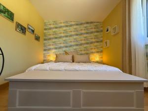 1 dormitorio con 1 cama grande y paredes amarillas en La Terrasse Étoilée, en Saint-Médard-dʼExcideuil