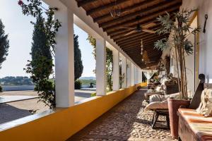 un patio esterno con divani e tavoli su un edificio di Herdade Do Sobroso Wine & Luxury Boutique Hotel a Pedrógão