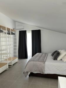 a white bedroom with a bed and a window at Acogedora Casa con terraza en Manilva in Manilva