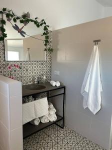 a bathroom with a sink and a mirror and towels at Acogedora Casa con terraza en Manilva in Manilva