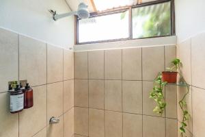 a bathroom with a shower with a window and a plant at Casa Mandala by Dreamcatcher in Sarchí +14 photos