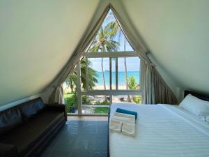 a bedroom with a bed and a large window at Urai Villa by Utalay Koh Chang in Ban Khlong Son