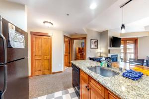 a kitchen with a sink and a refrigerator at Copper One 407 in Frisco +17 photos