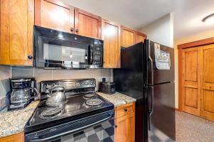 a kitchen with a black stove and a refrigerator at Copper One 407 in Frisco