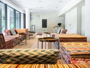 a living room with couches and tables and a tv at Novotel Wien Hauptbahnhof in Vienna