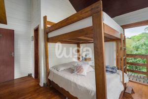 um quarto com um beliche de madeira e uma janela em Suíte Front Paraíso dos Ciclistas em Gramado