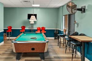 a pool table in a room with red chairs at Quality Inn & Suites Aiken East in Aiken