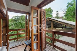 um quarto com uma porta e uma cadeira numa varanda em Suíte Front Paraíso dos Ciclistas em Gramado