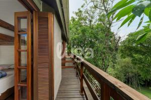 uma varanda de uma casa com uma porta de madeira em Suíte Front Paraíso dos Ciclistas em Gramado