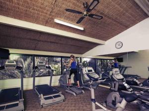 a woman standing in a gym with cardio equipment at Mercure Alice Springs Resort in Alice Springs