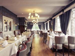 a dining room with white tables and chairs at Mercure Thame Lambert Hotel in Chinnor
