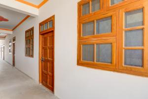 an empty hallway with wooden doors and windows at Hotel O SK in Sītāpur